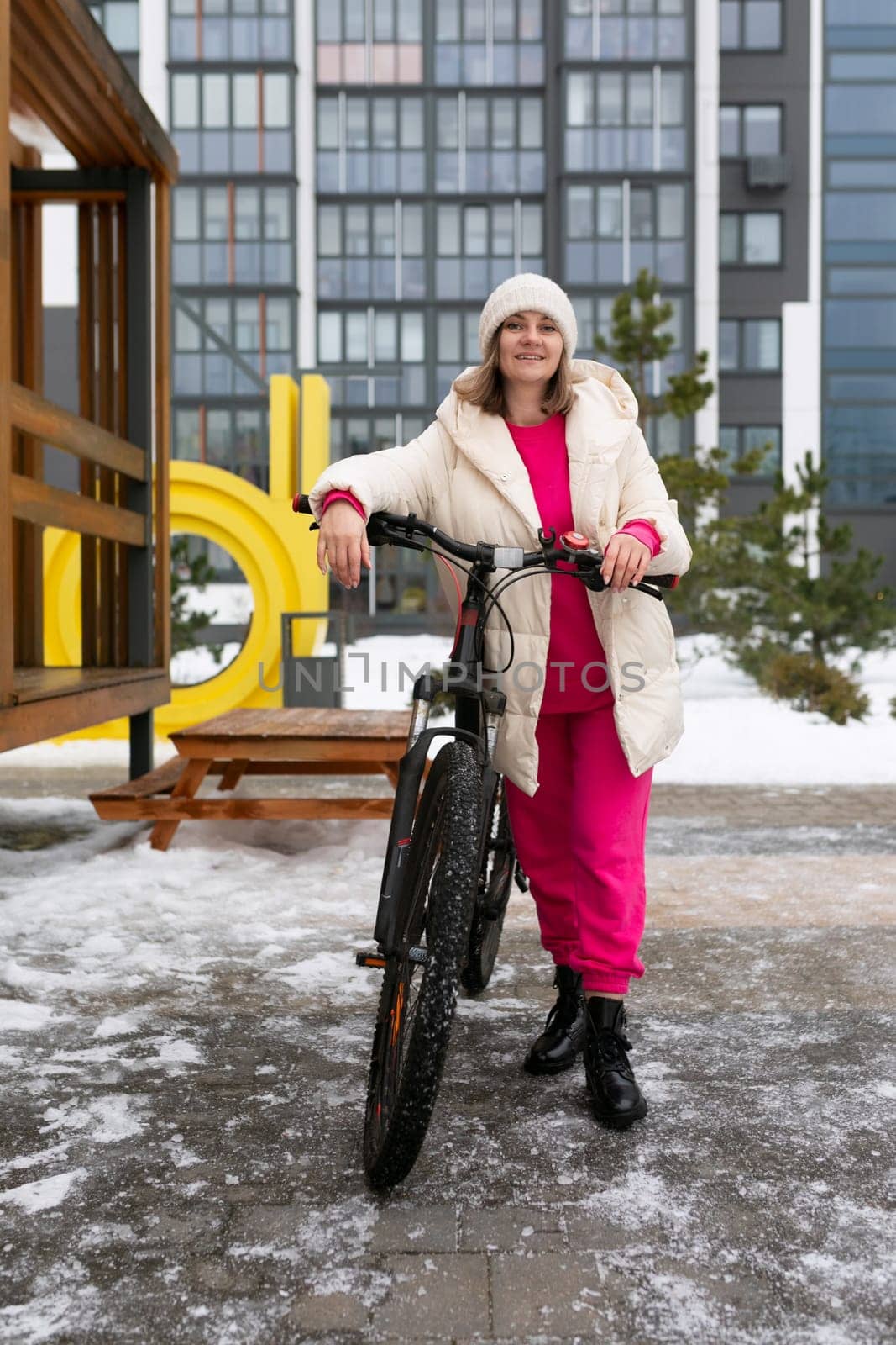 Woman Standing Next to Bike in Snow by TRMK