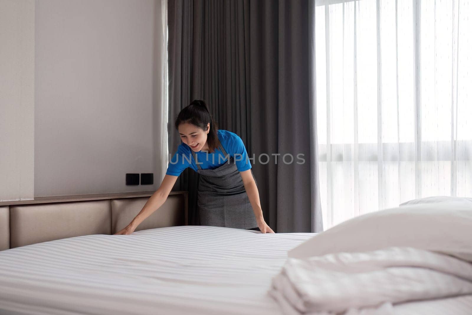 A woman asian staff cleaning service, tool and bucket for work. a young female cleaner with products to clean a bedroom.