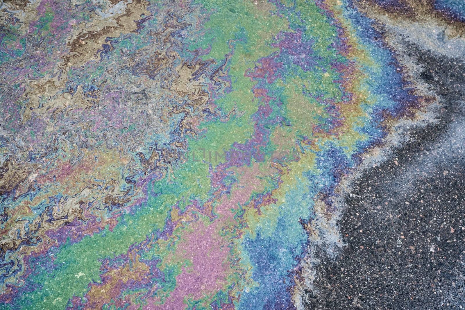 Leakage of oil or gasoline from a car onto a wet asphalt road. Environmental pollution concept