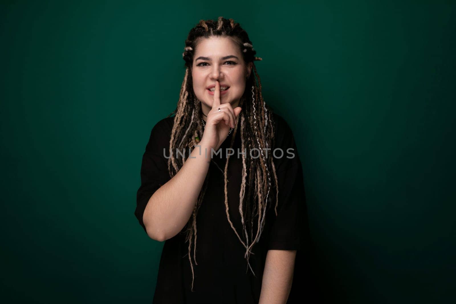 Woman With Long Dreadlocks Standing in Front of Green Wall by TRMK