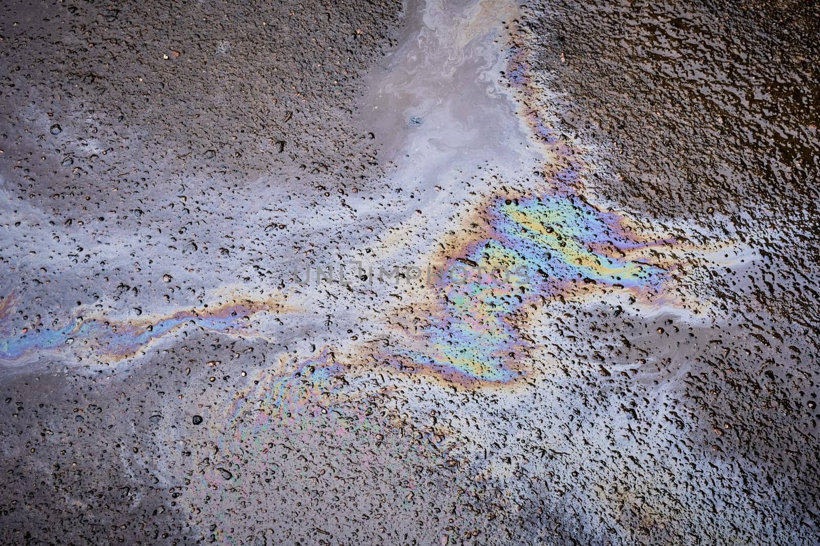 Bold multicolored spots on the asphalt. Concept of environmental problems