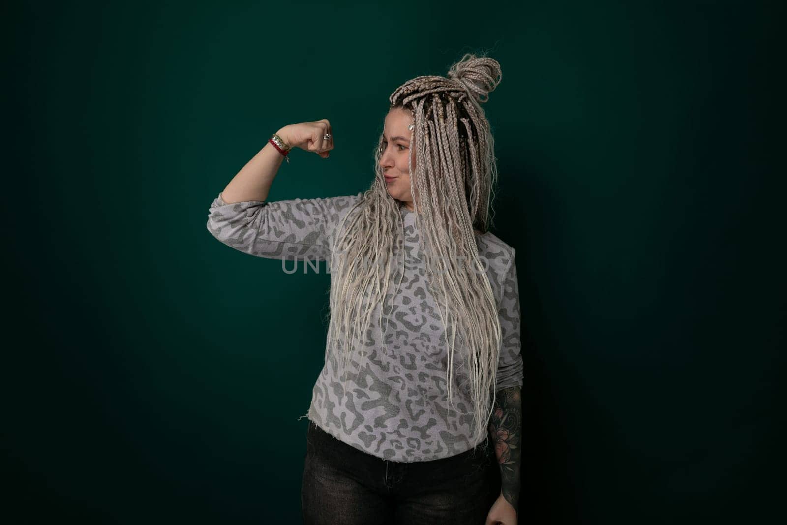 Woman With Dreadlocks Standing in Front of a Green Wall by TRMK