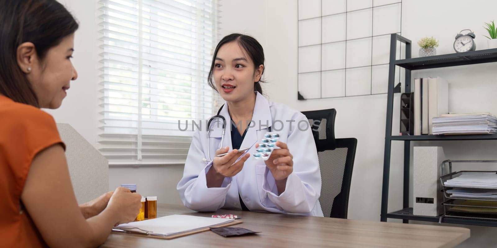 Doctor woman are recommend medicine to elderly woman patient after being examine by the patient doctor, the concept of treatment and symptomatic medication dispensing by the pharmacist by nateemee