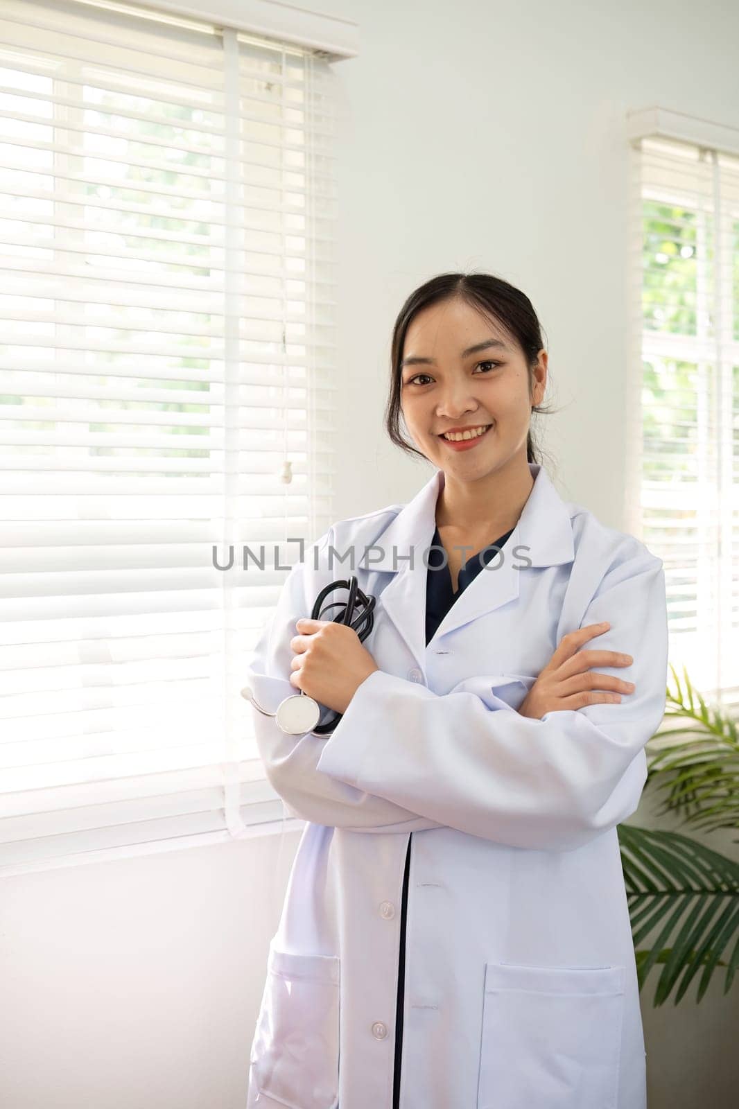 Confident female doctor Smiling woman standing holding stethoscope in clinic.