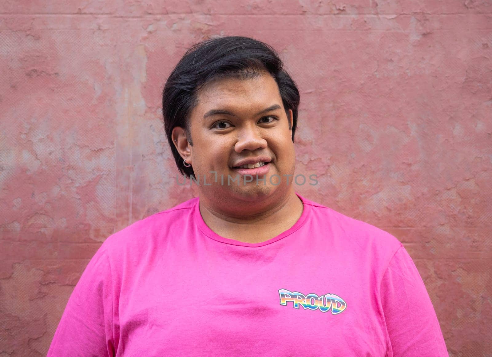 Portrait of asian man smiling with a shirt that he is proud to support homosexual community by papatonic