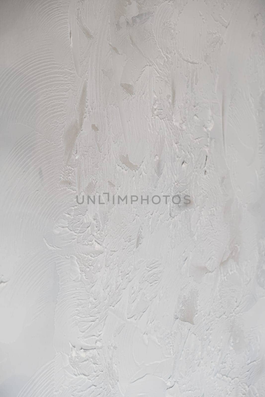 Applying decorative putty. White abstract texture of surface covered with putty by AnatoliiFoto