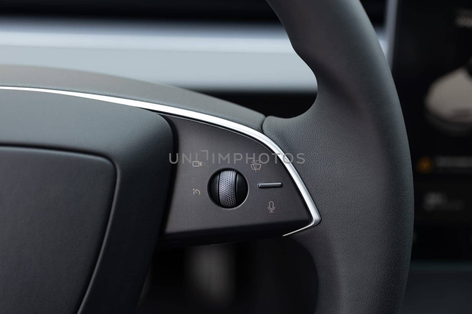 Steering wheel of electric vehicle, interior, cockpit, electric buttons. Electric car interior luxury. Interior of prestige modern car. Autonomous car. Driverless car. Self-driving vehicle.