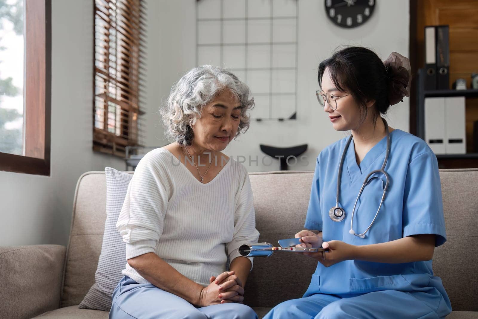 Elderly caregivers are helping to check the health and care for an elderly woman at home..
