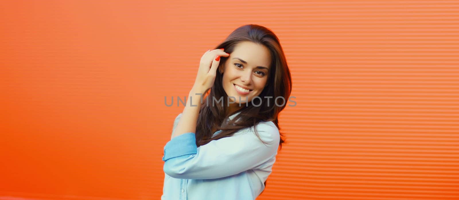 Portrait of beautiful happy smiling brunette young woman posing in the city