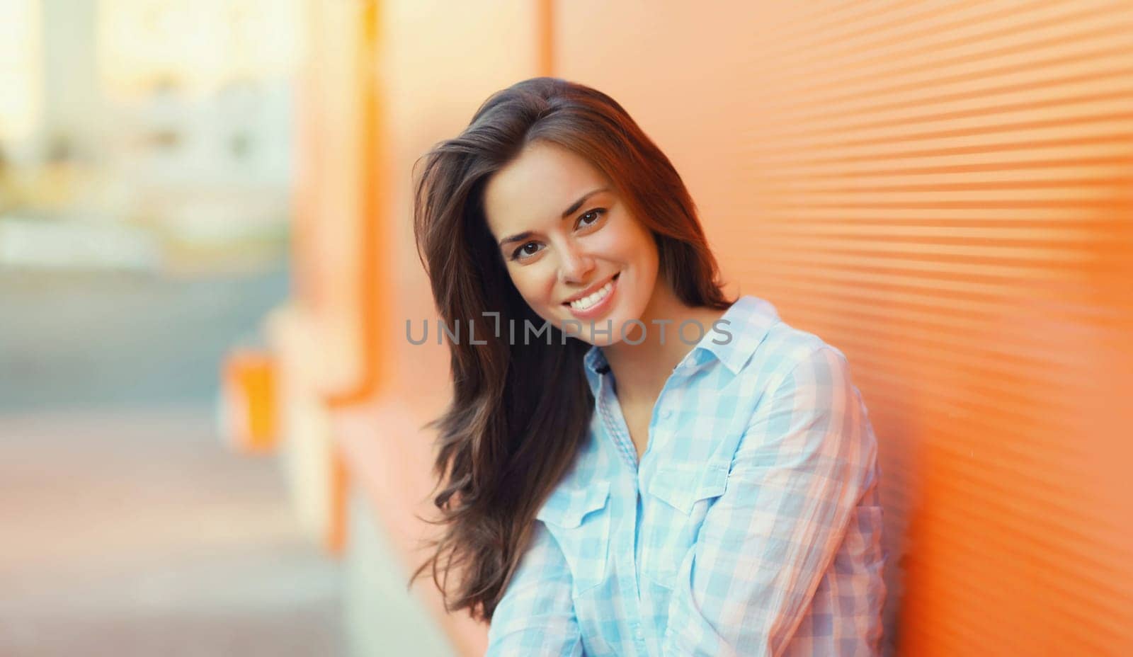 Portrait of beautiful happy smiling brunette young woman posing in the city