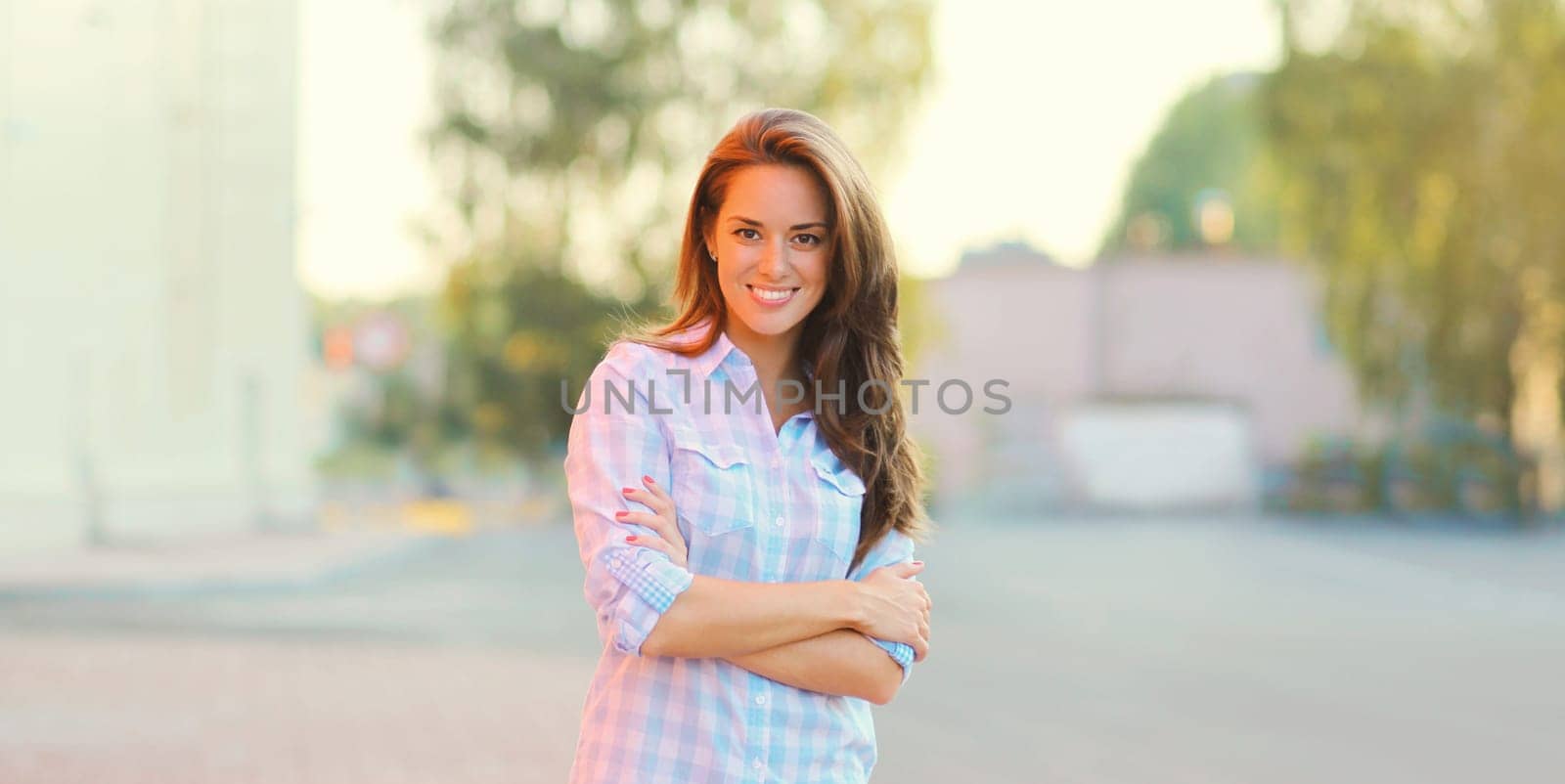 Portrait of beautiful happy smiling brunette young woman posing in the city