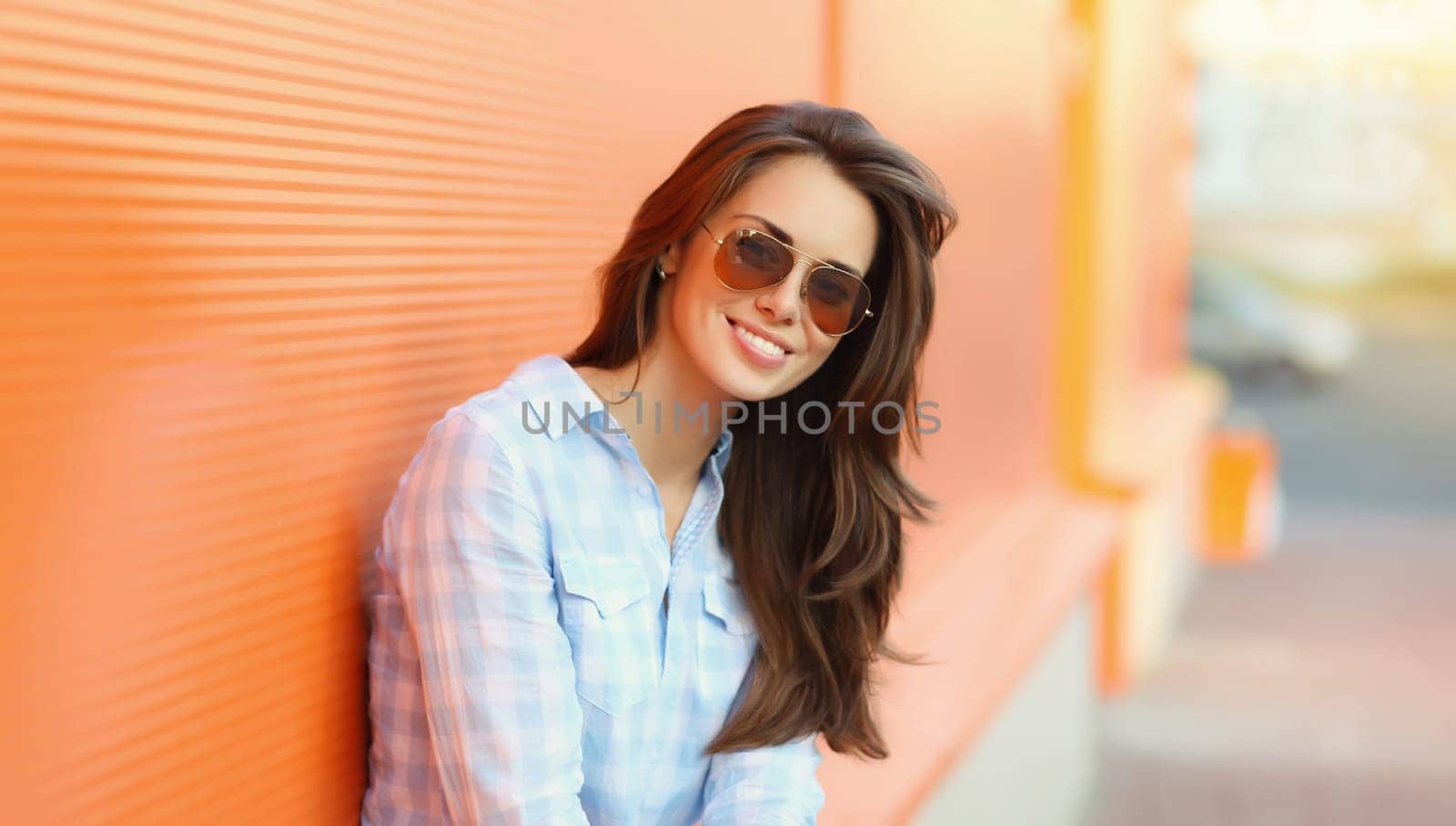 Portrait of beautiful happy smiling brunette young woman posing in the city