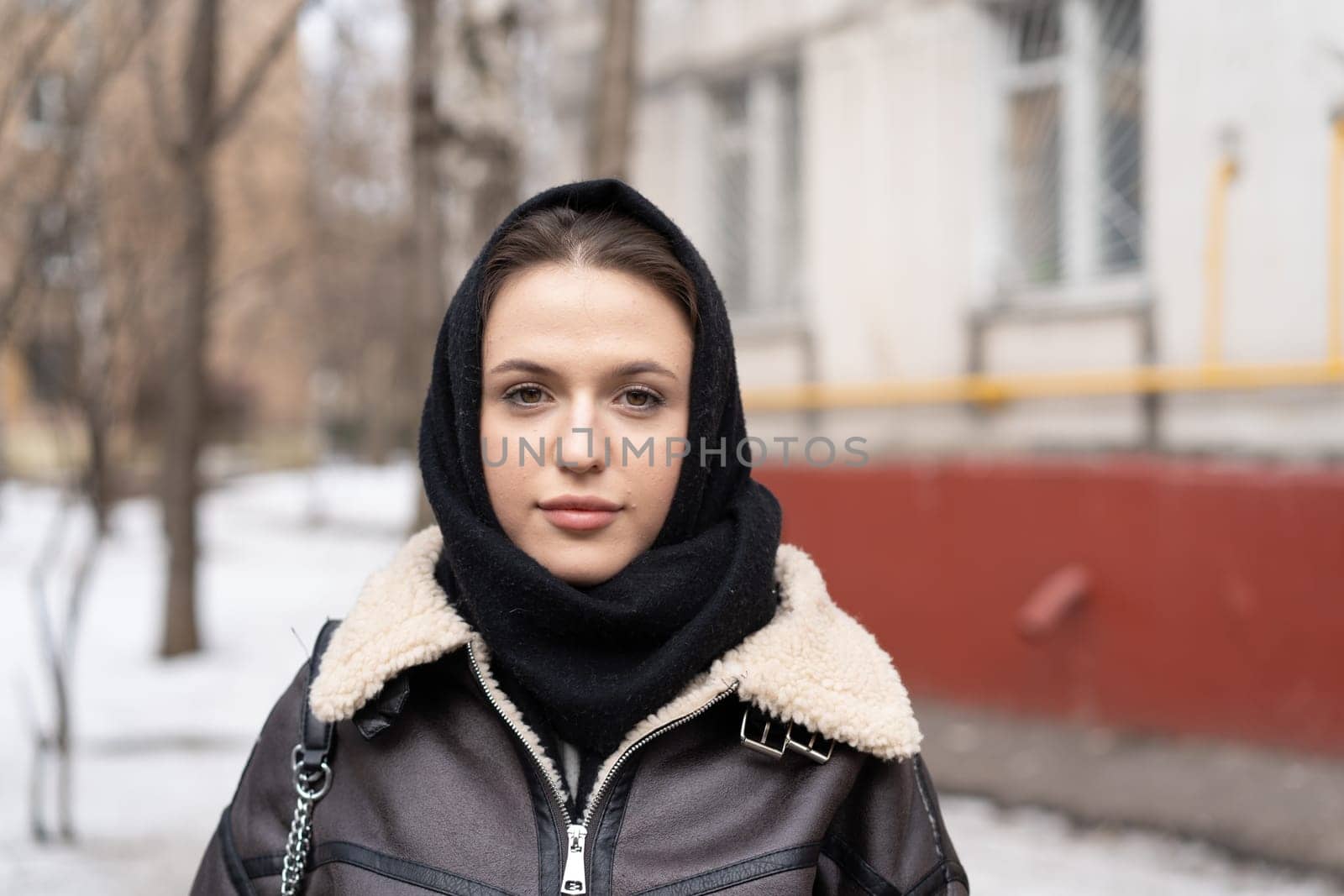 portrait of a young beautiful woman outside wearing a headscarf