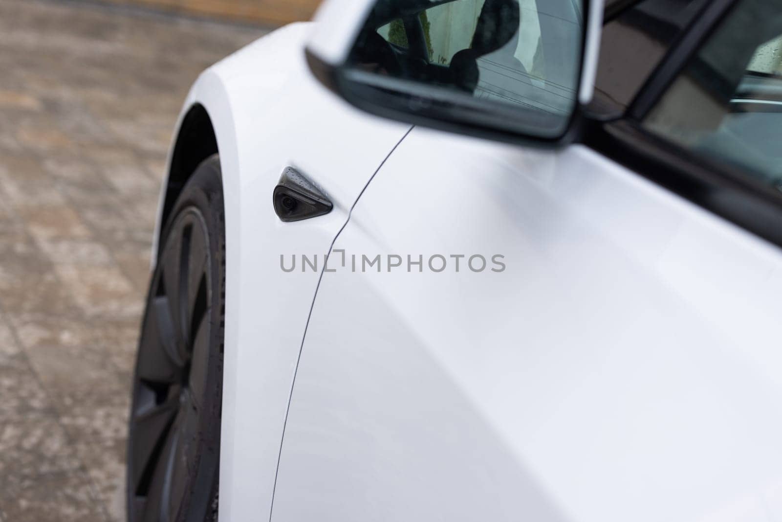 Lviv, Ukraine - March 23, 2024: White Tesla Model 3 highland electric car. Self-driving vehicle. Tesla side repeater camera. Closeup of one of the Autopilot cameras on a new Tesla model 3.