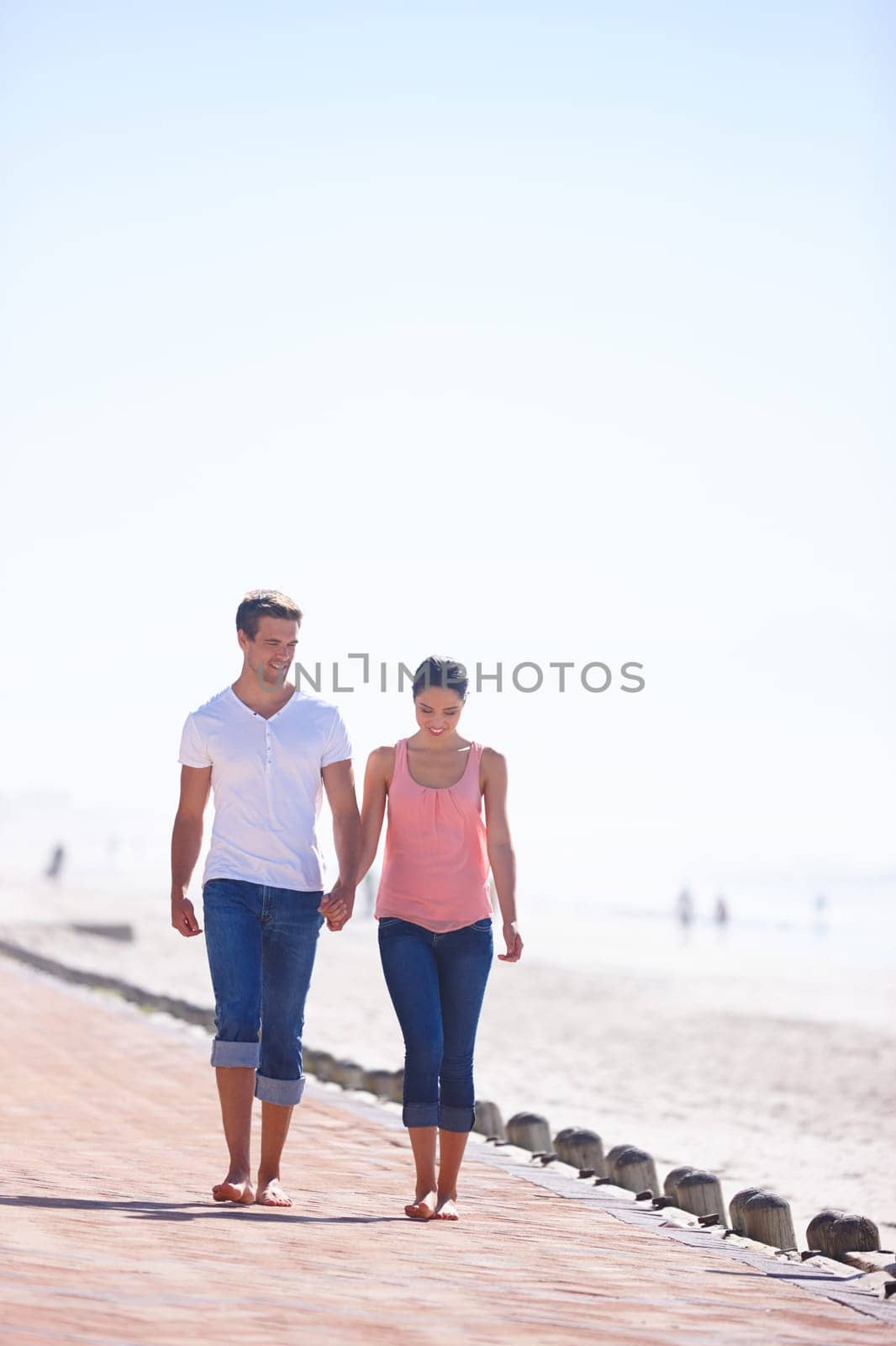 Man, woman and holding hands with walking on beach, romantic date and commitment with trust. Love, care and people together outdoor for anniversary, bonding and relax by sea with partner for travel.