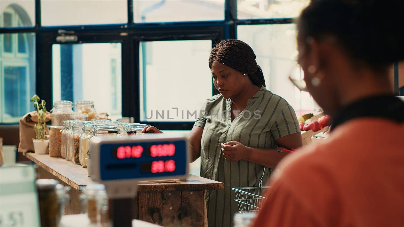 Customer checking organic bio merchandise in grocery store, looking for additives free pasta or pantry items to buy weekly supplies. African american woman searching for nonpolluting goods.