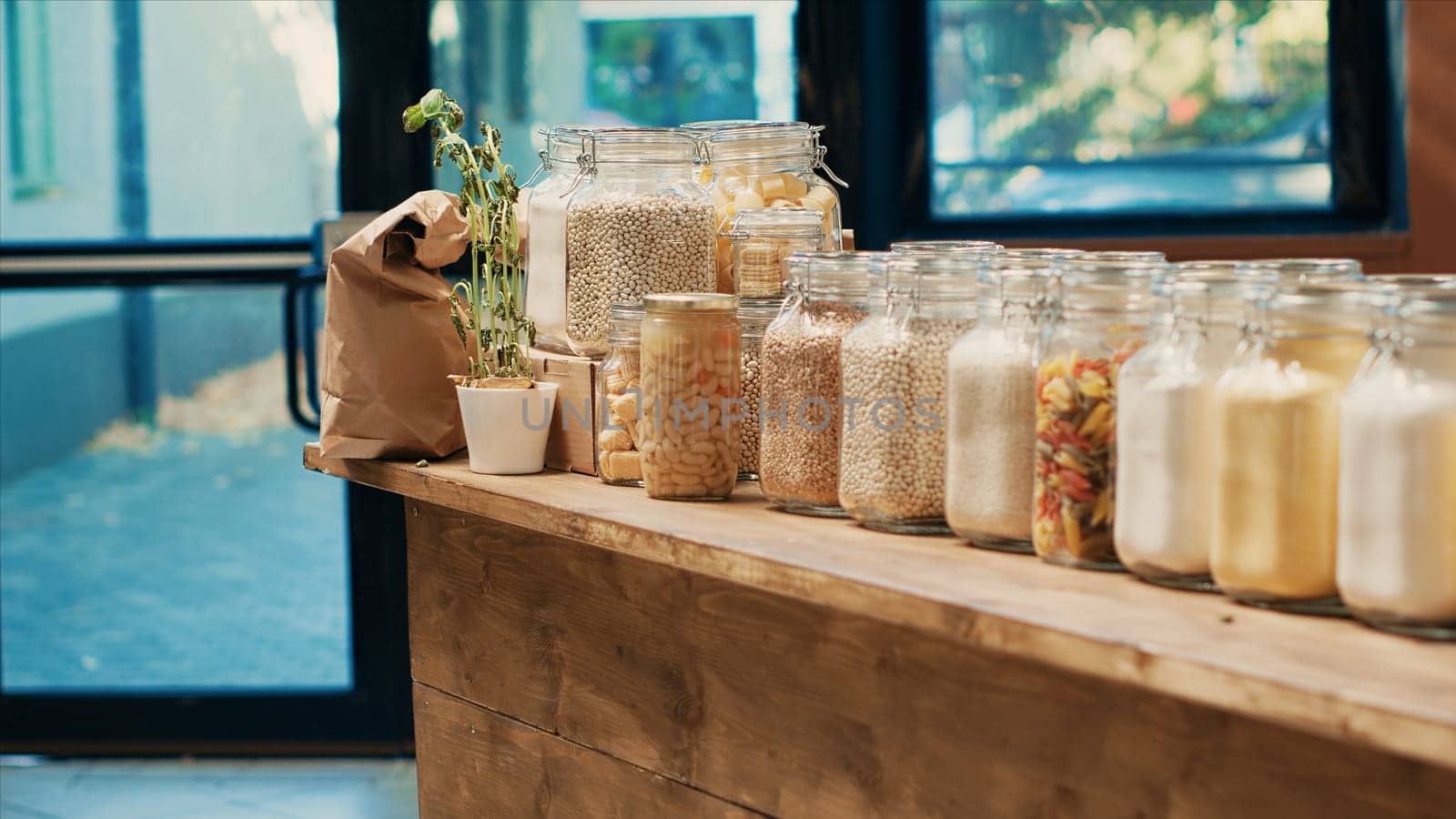 Chemicals free pasta and cereals in eco friendly supermarket, pantry supplies displayed in reusable glass jars on shelves. Organic fresh food and homemade sauces for sustainable lifestyle.