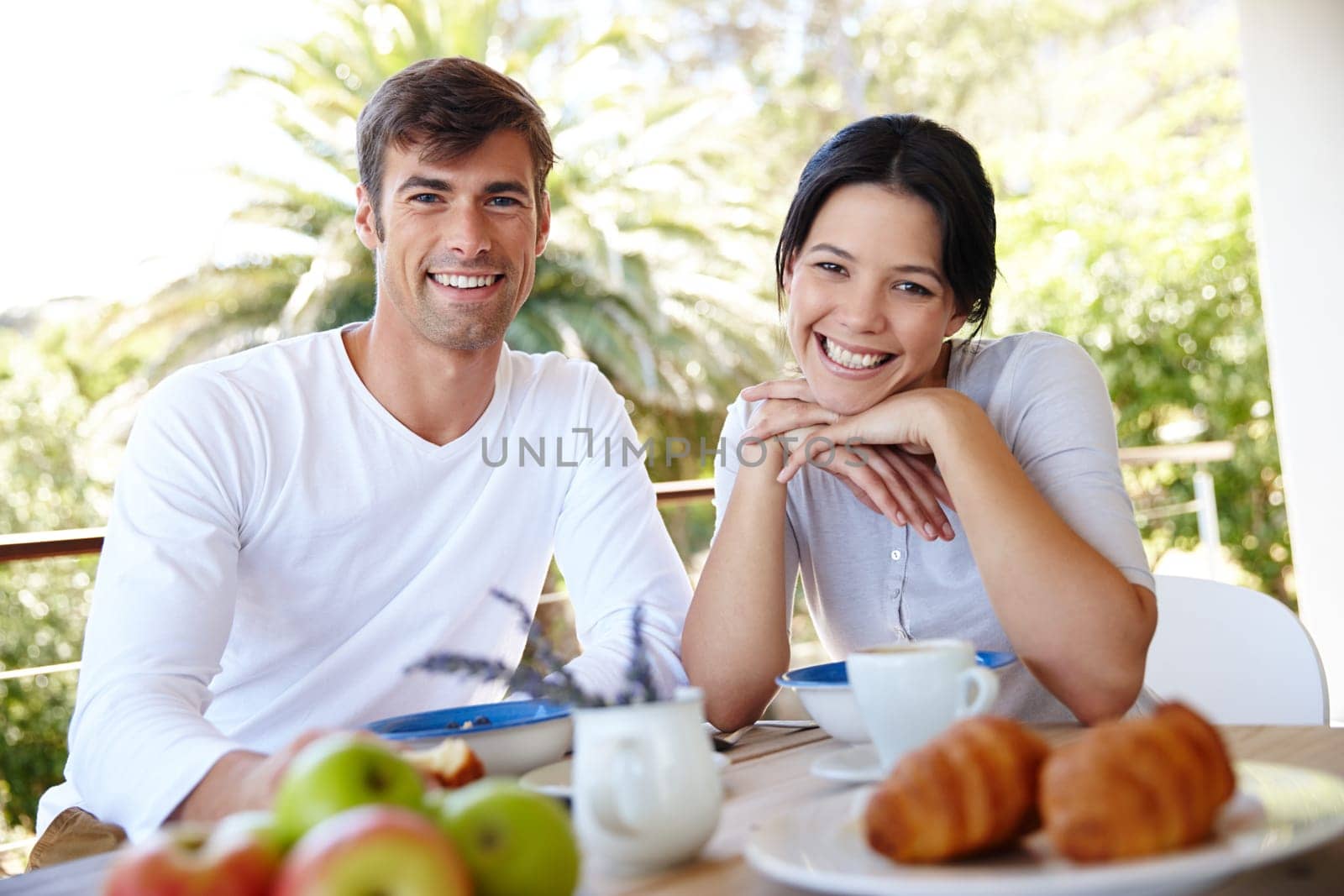 Couple, balcony and outdoor portrait for meal, love and affection in marriage or romance in nature. People, nutrition and smile at breakfast for healthy relationship, food and relax on vacation by YuriArcurs