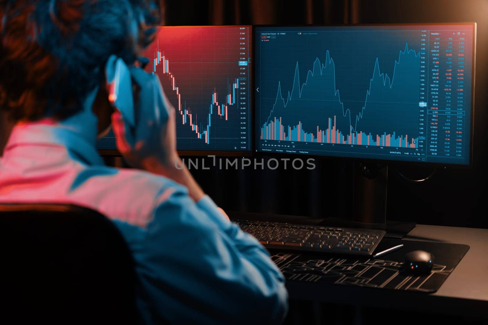 Young investor stock trader calling with broker to invest earning highest profit on current market graph online in real time at neon light modern office, monitor showing investment exchange. Gusher.