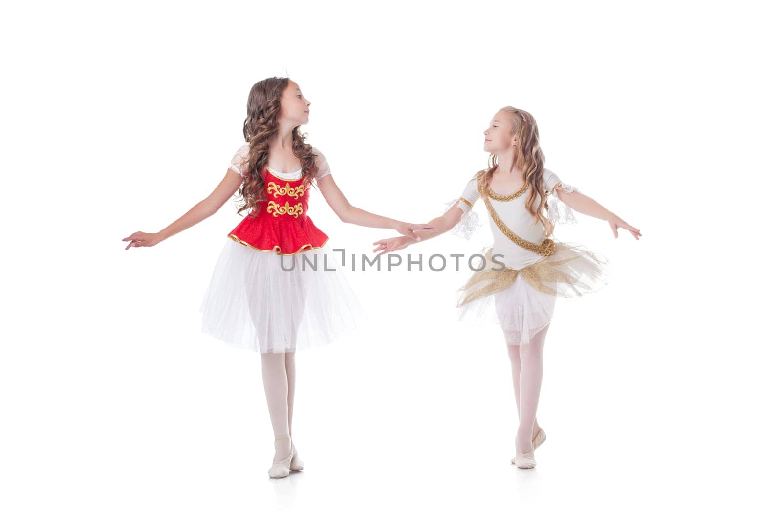 Cute young ballerinas looking at each other while dancing