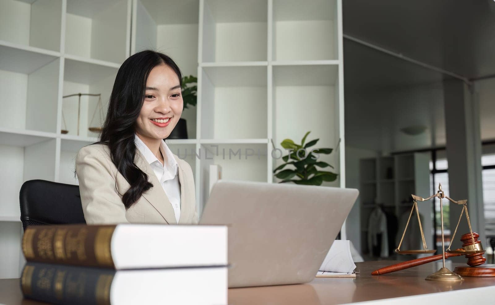 A female Asian lawyer reviews business and real estate laws. Legal consultants provide legal advice and guidance online via laptops in lawyers' offices. by wichayada