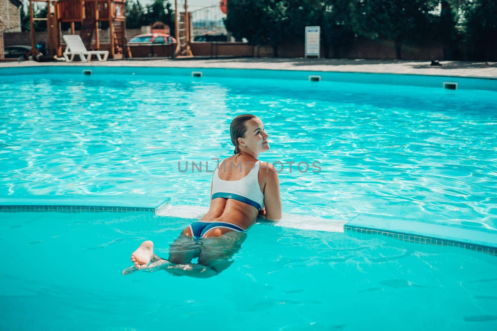 woman swimming pool. happy woman with wet hair and stylish sunglasses sunbathing in pool by Matiunina