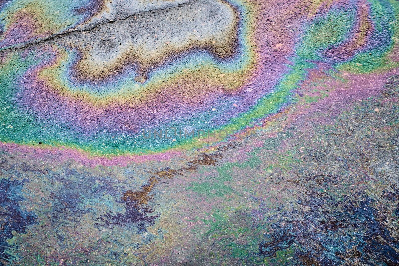 Textured stain of fuel or oil on wet asphalt on a rainy day. The concept of environmental pollution.
