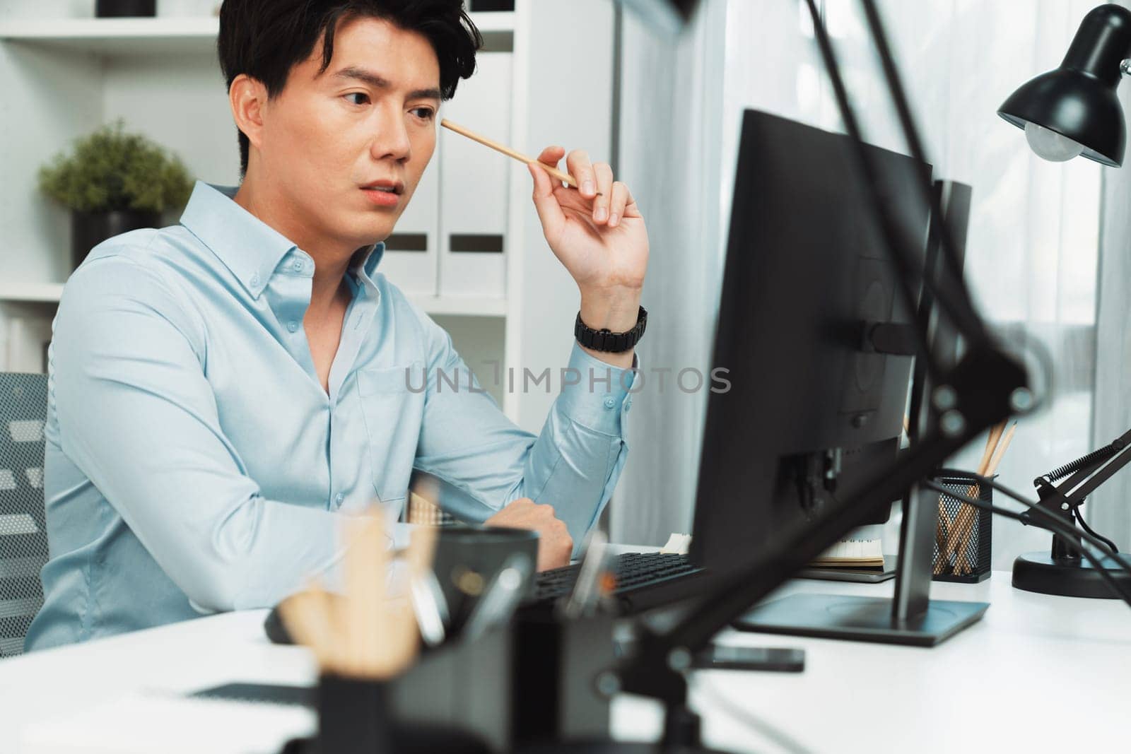 Serious smart businessman working on computer to check email with business project report, analyzing on market share's customer database in casual day at modern office in startup concept. Infobahn.