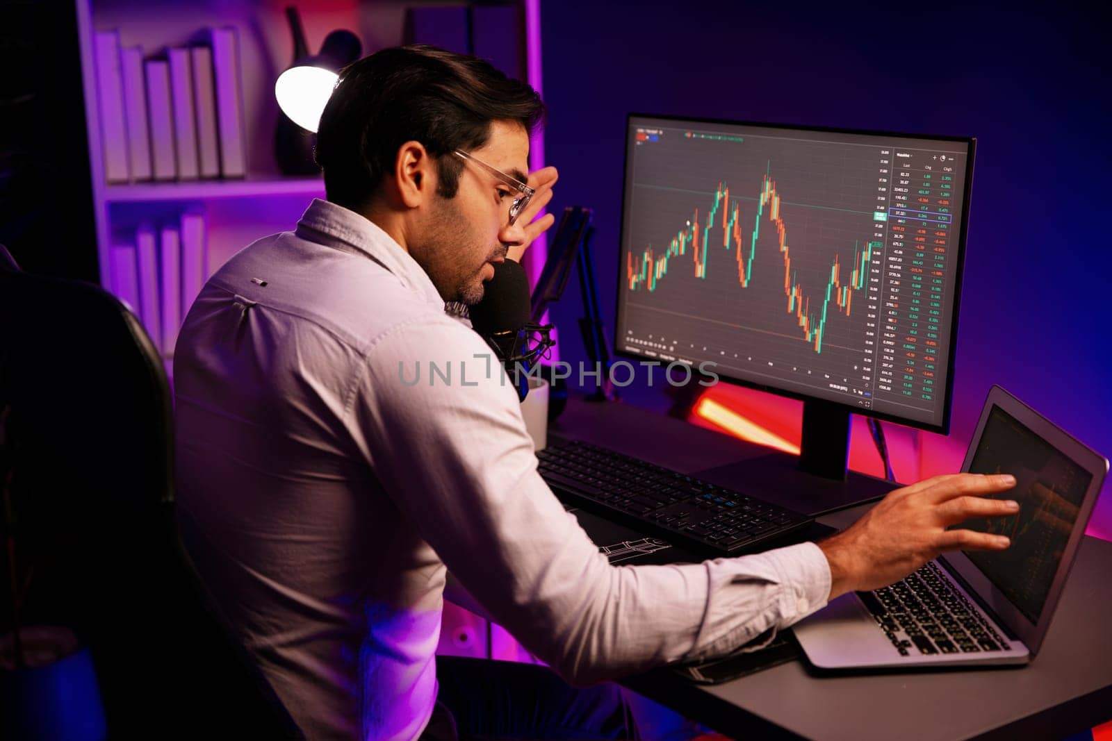 Smart trader concentrating on dynamic stock exchange on pc and laptop. Surmise. by biancoblue
