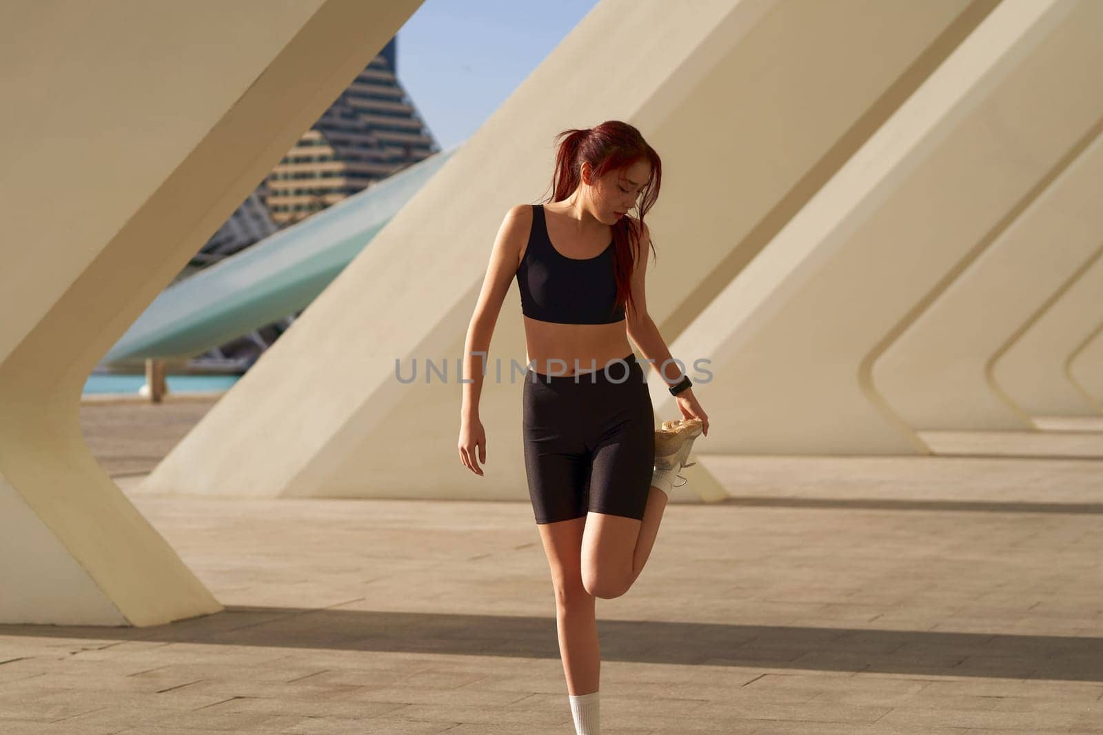 Young sportswoman in tracksuit is stretching outdoor and preparing to jogging. Healthy life concept by Yaroslav_astakhov