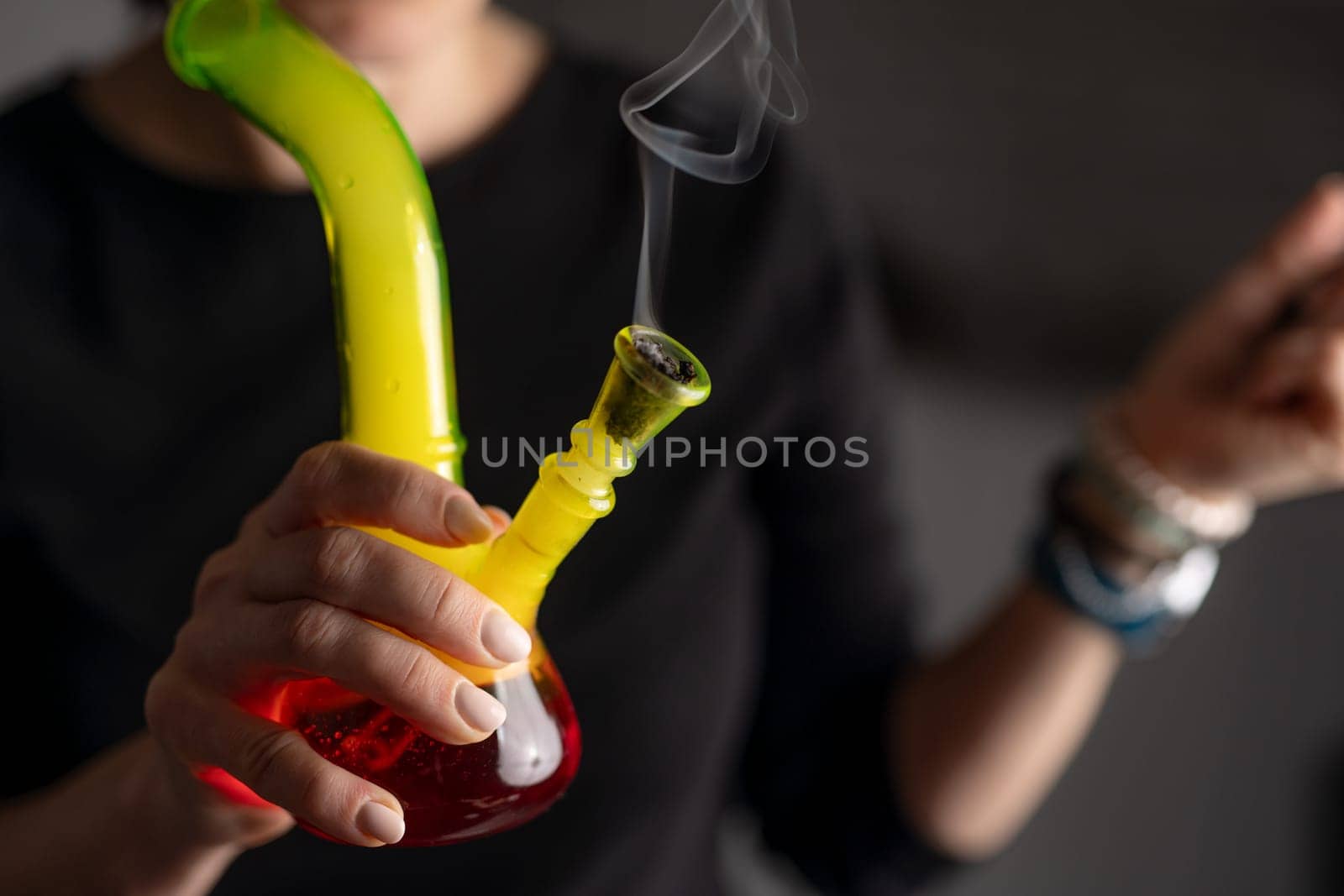 Woman Smokes Cannabis With Bong In Close-Up View