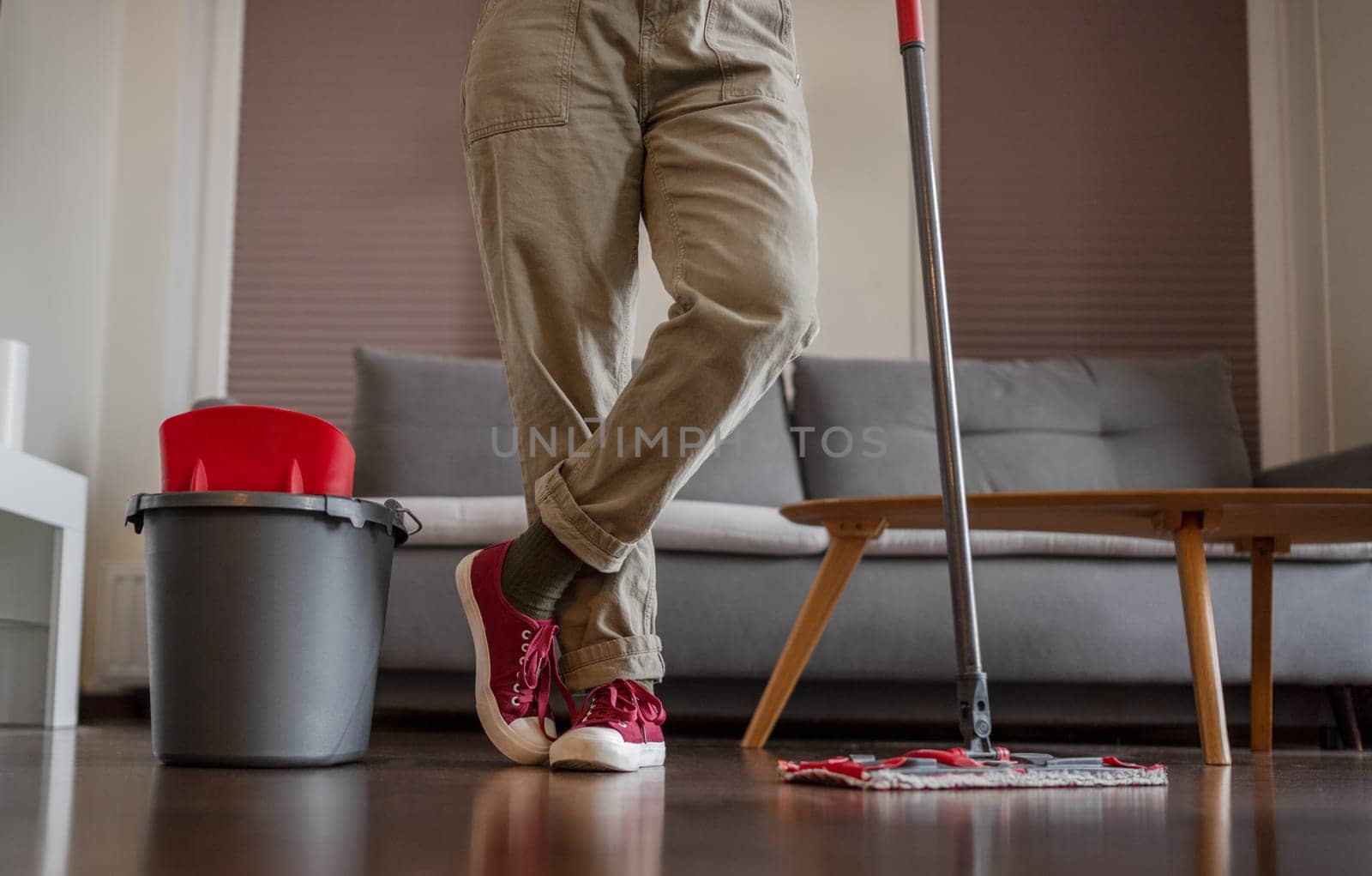 Housewife Stands With Mop In Room, Close-Up Of Face Not Visible