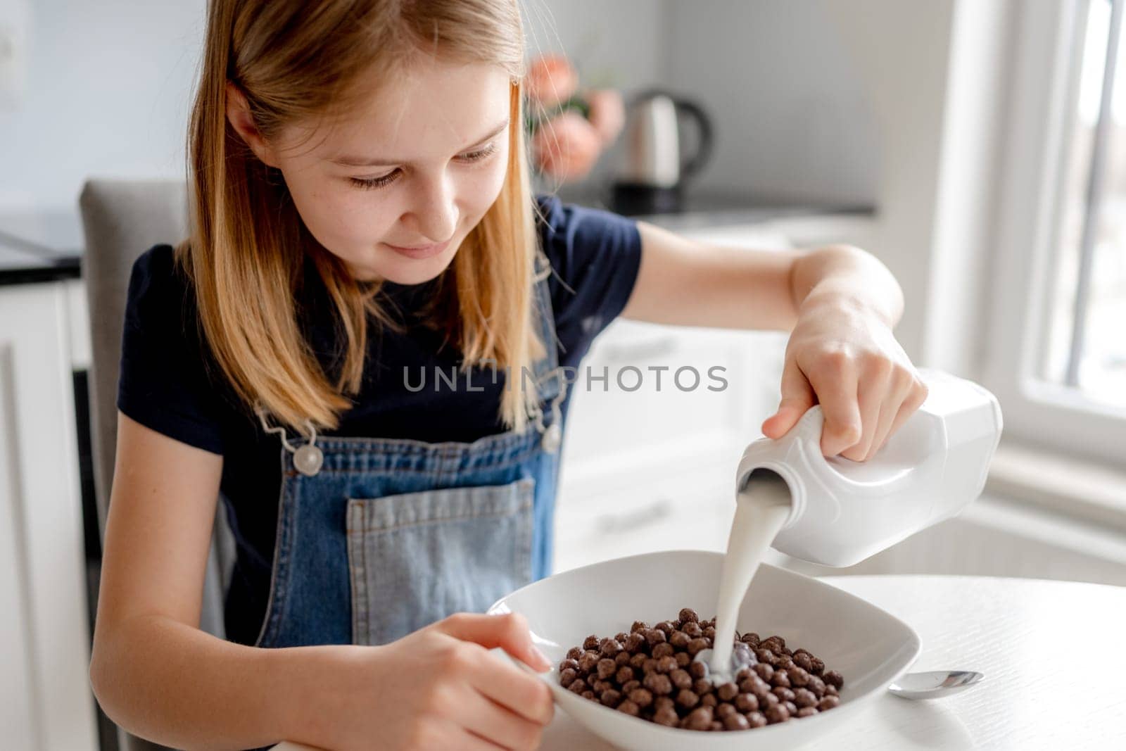 Cute Girl Pours Milk Into Bowl With Cereal by tan4ikk1