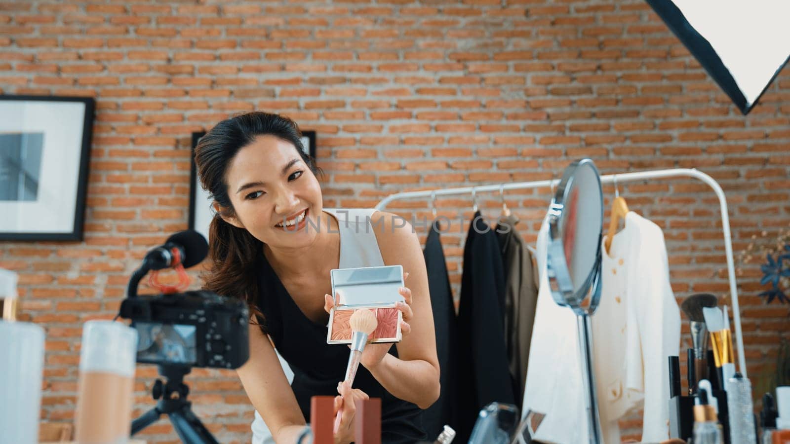 Woman influencer shoot live streaming vlog video review vivancy makeup social media or blog. Happy young girl with cosmetics studio lighting for marketing recording session broadcasting online.