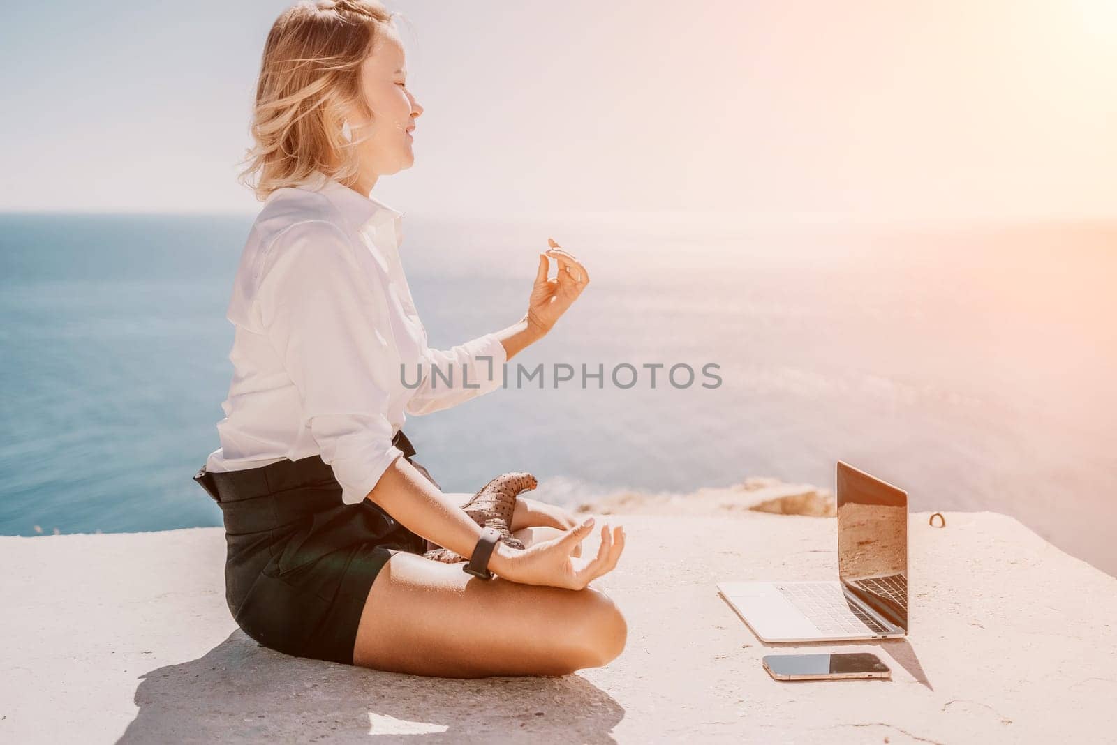 Woman sea laptop yoga. Business woman freelancer in yoga pose working over blue sea beach at laptop and meditates. Girl relieves stress from work. Freelance, digital nomad, travel and holidays concept by panophotograph