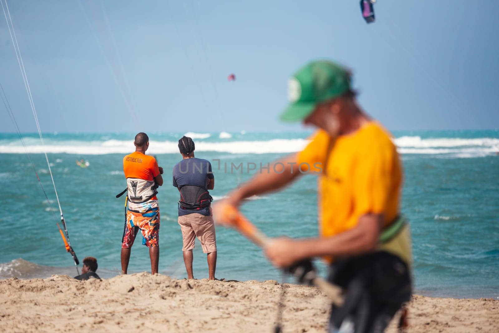 Active sporty people enjoying kitesurfing holidays and activities on perfect sunny day on Cabarete tropical sandy beach in Dominican Republic. by kasto