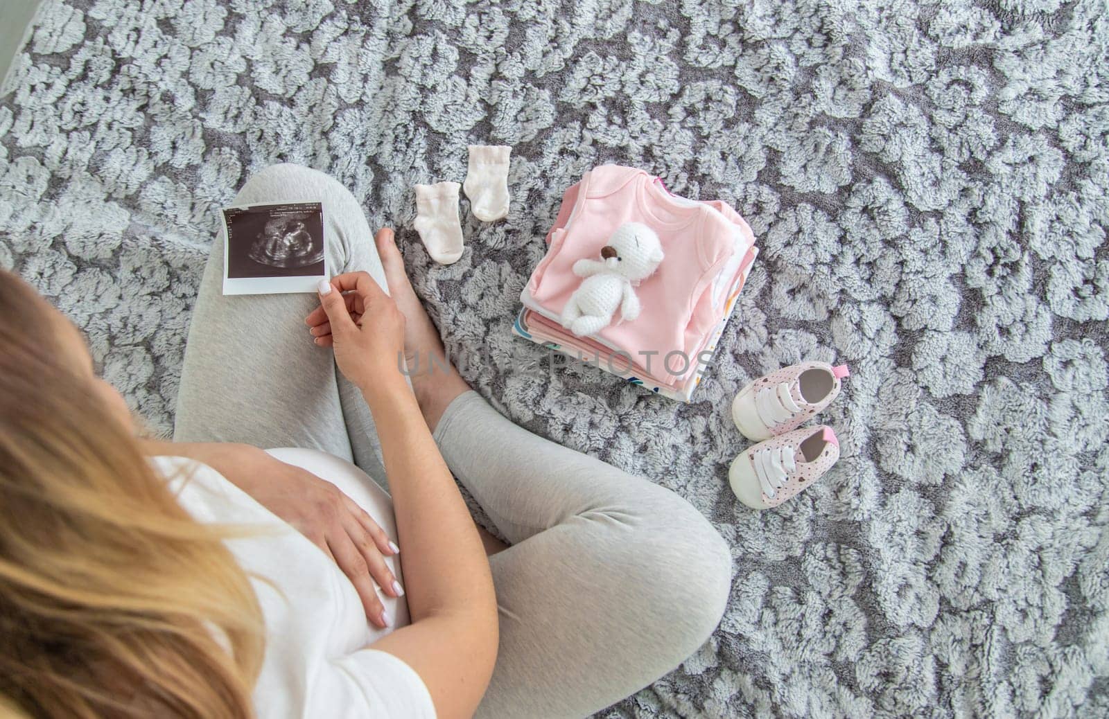 A pregnant woman collects baby things. Selective focus. Home.