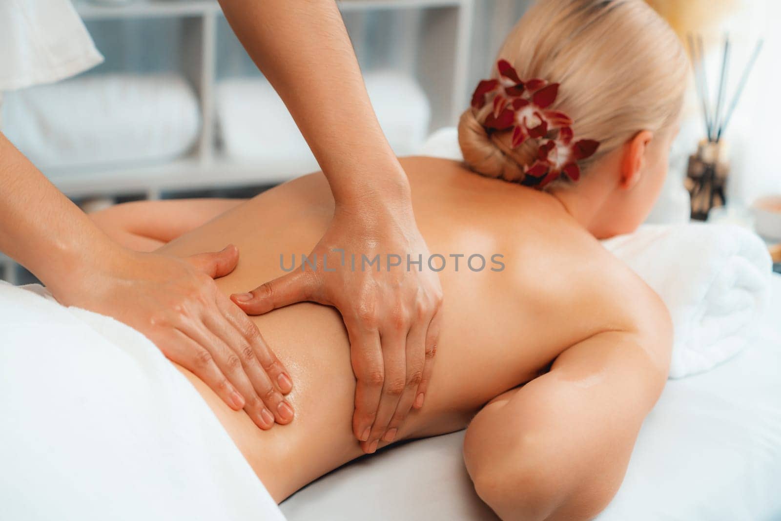 Caucasian woman customer enjoying relaxing anti-stress spa massage and pampering with beauty skin recreation leisure in day light ambient salon spa at luxury resort or hotel. Quiescent