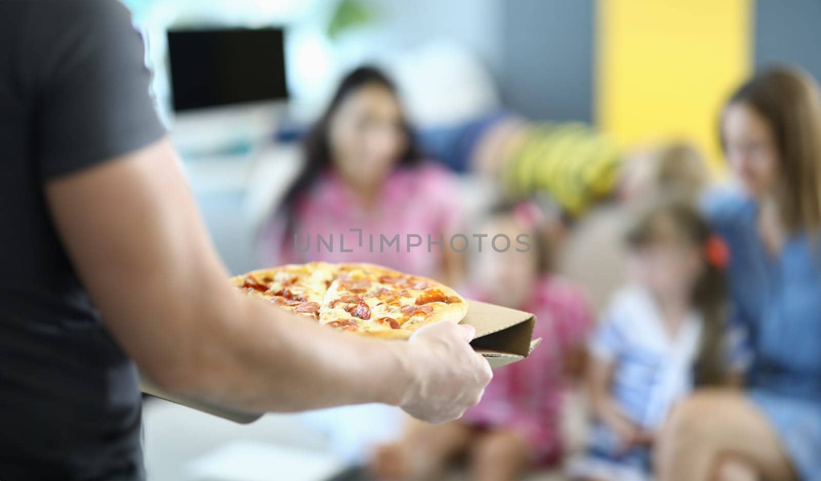 Male hands carry pizza on cardboard stand close up. by kuprevich