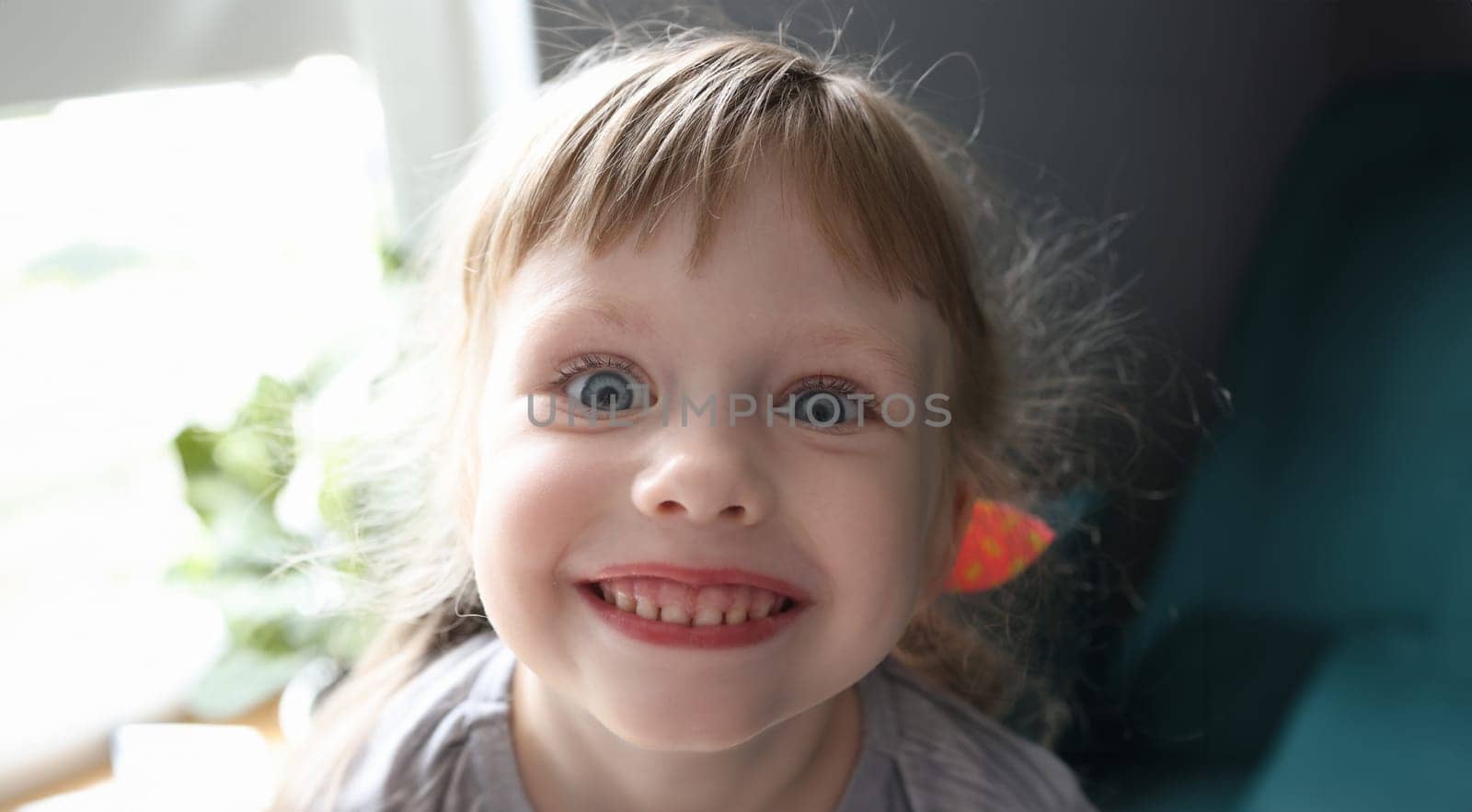 Happy child close-up portrait. Girl face with blue eyes close up smile.