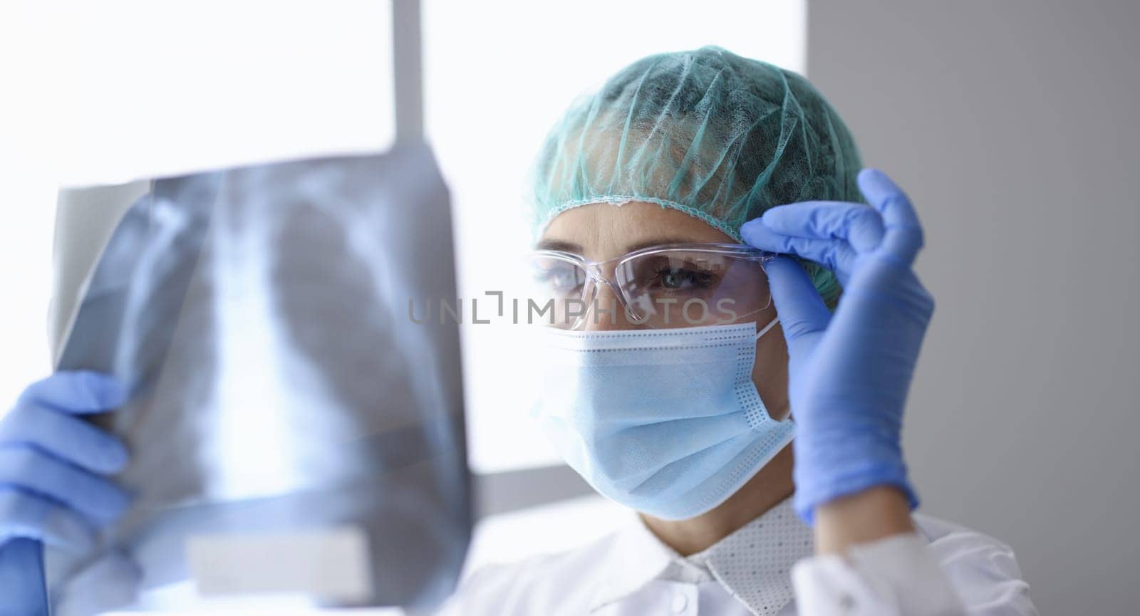 Woman in protective mask and suit hold snapshot of lungs. by kuprevich