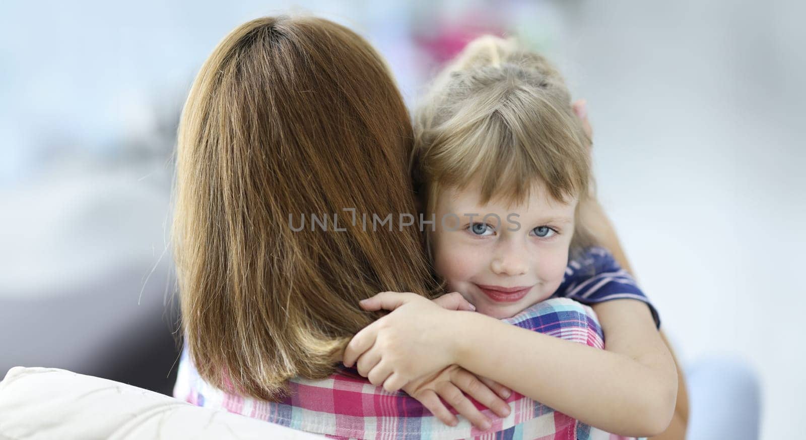 Little beautiful girl hugs her mother and smiling portrait. Social guarantees for women with children during divorce concept.