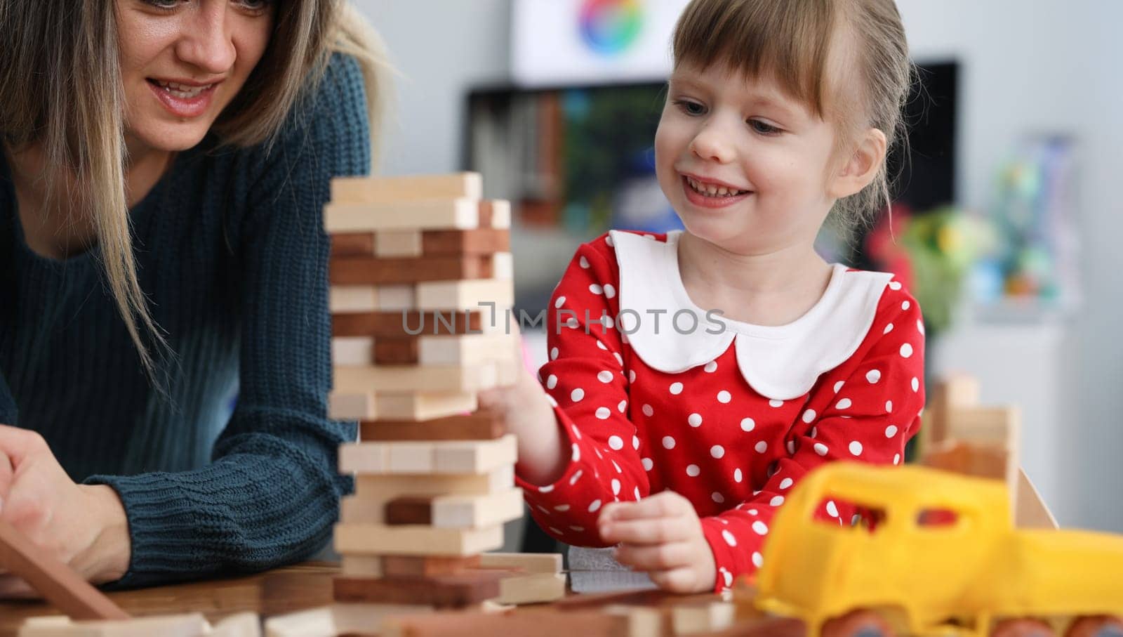 Mom and daughter are sitting at table playing game. Vision attention memory and perception child. Girl has good memory and concentration. Interesting entertainment for family circle