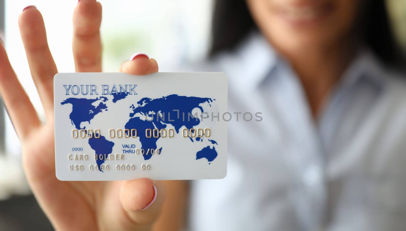 Woman arm holding banking card showing it to camera by kuprevich