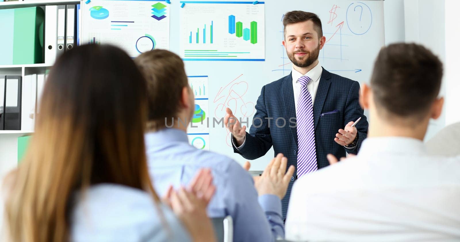Bunch of people listening man in suit and tie telling something about financial concept