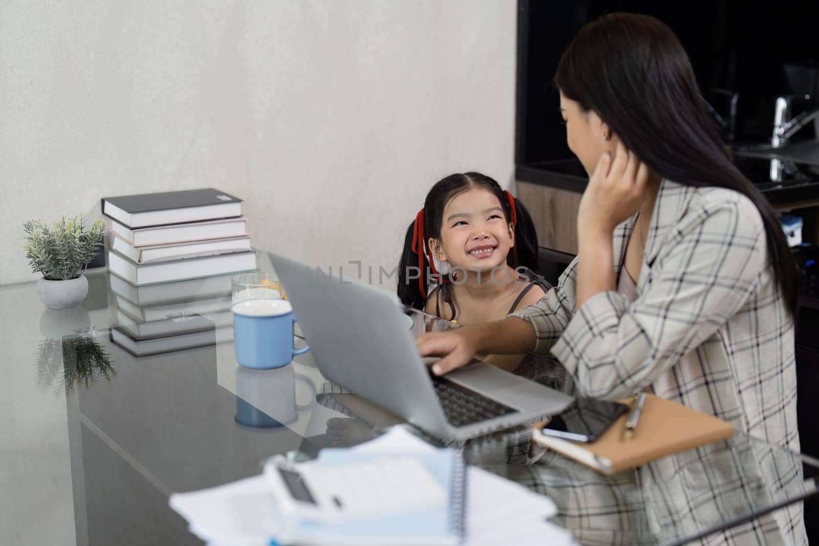 Businessman working at home. working woman talk on mobile and working on tablet and take care of her daughter during summer.