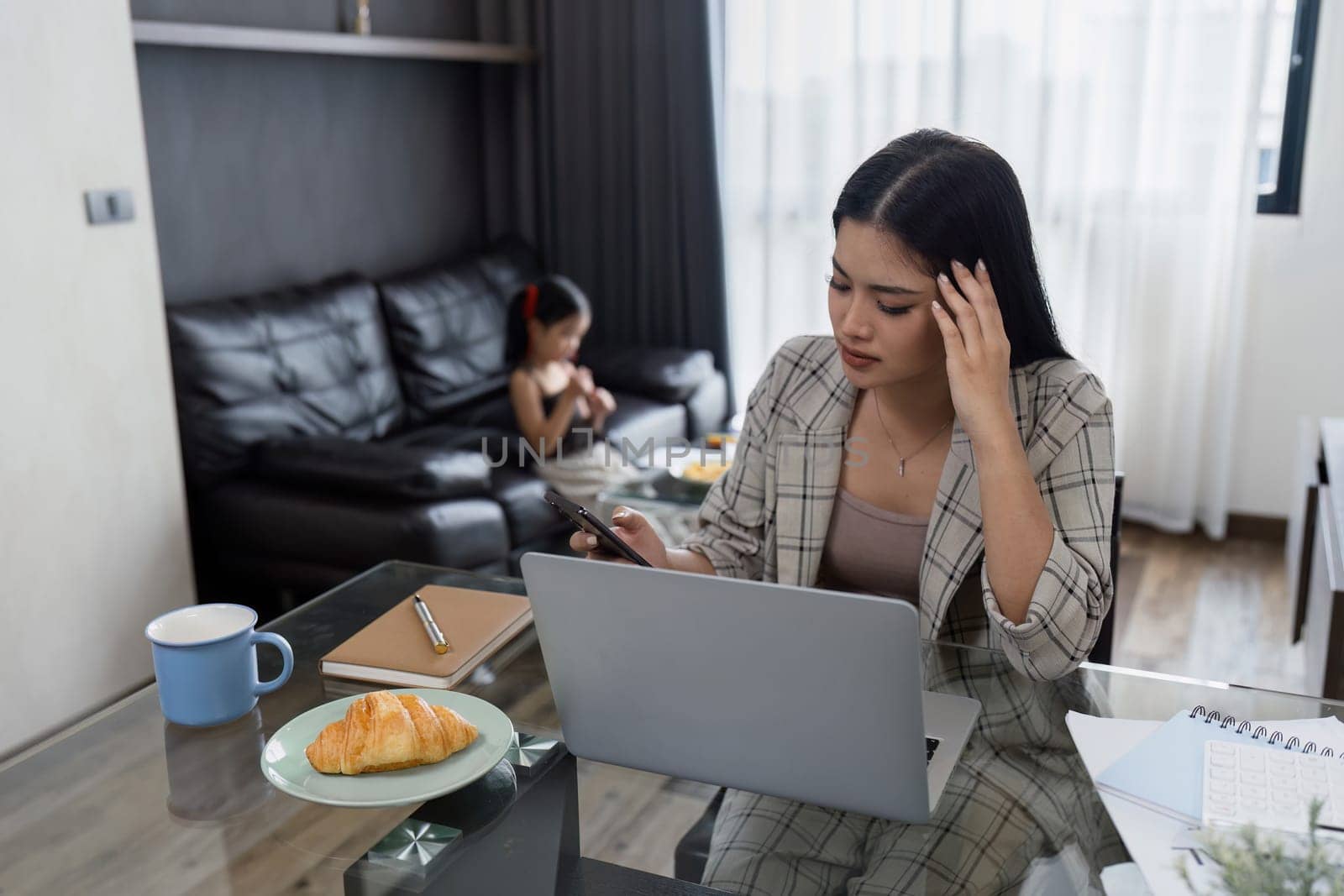 Business woman working at home. working woman working on laptop and take care of her daughter during summer by itchaznong