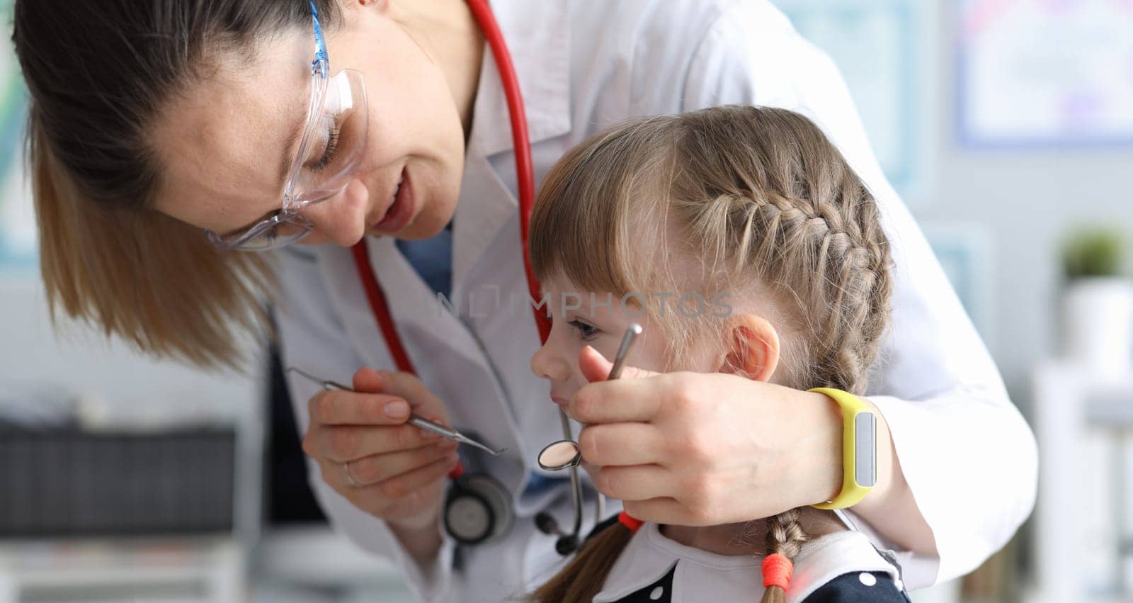 Pediatric dentist examines teeth little girl. Examination oral cavity in children at various age periods. Identification pathological conditions teeth in girl. Diseases development in children