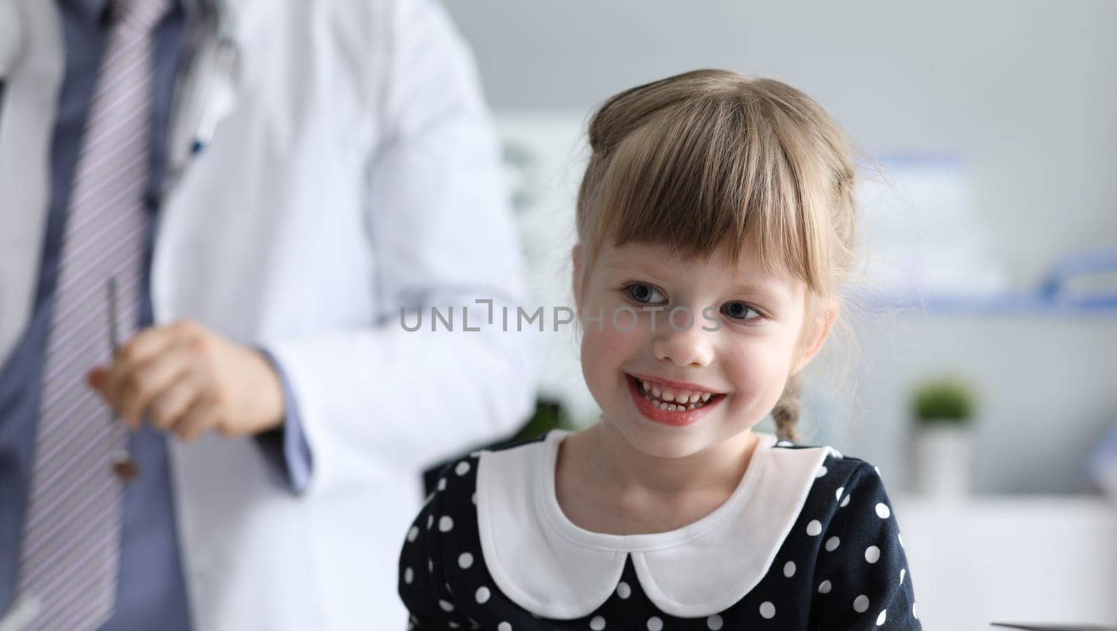 Healthy little girl is sitting in doctors office by kuprevich