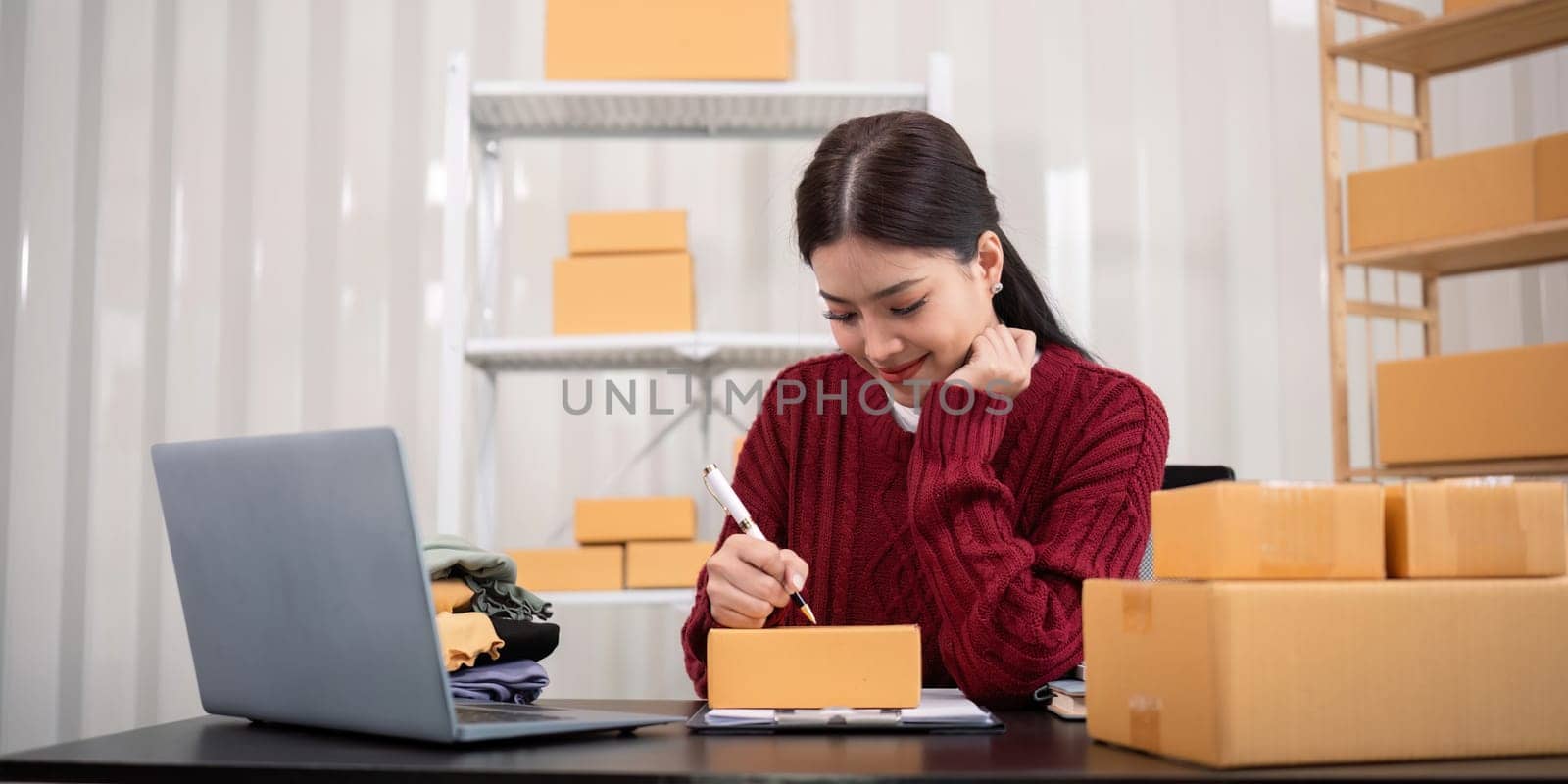 Asian woman small business entrepreneur working from home use tablet for commercial inspection. online marketing Packaging box, concept ecommerce.